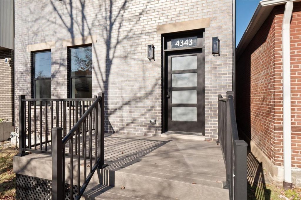 New build entrance with black door and brick facade