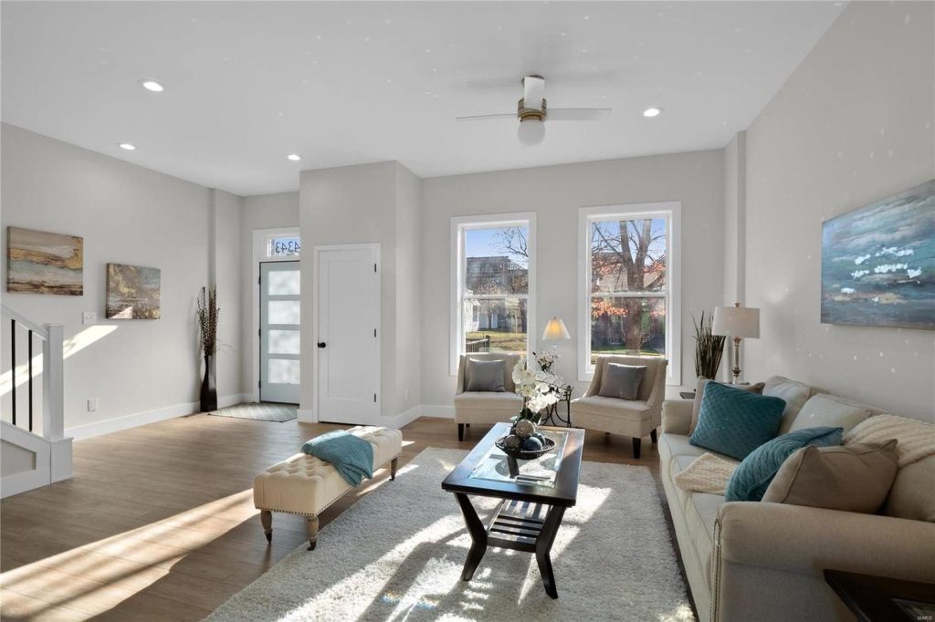 Living room with sofa, ottoman and picture windows