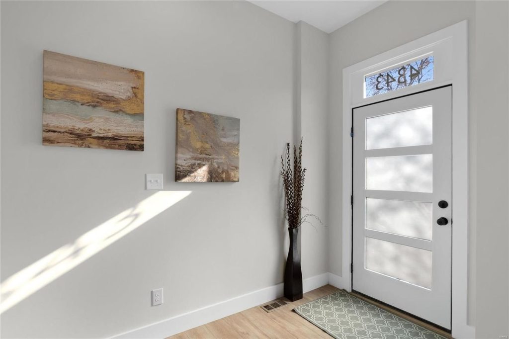 Entry hall with front door and framed artwork