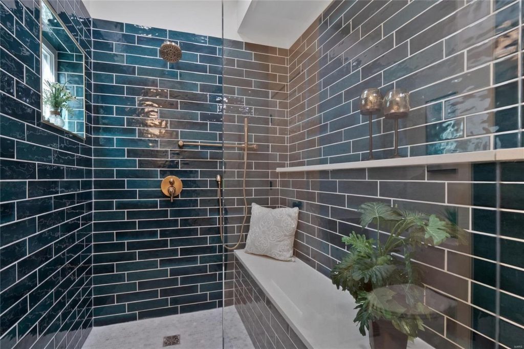Walk-in shower with dark teal tile and built-in bench