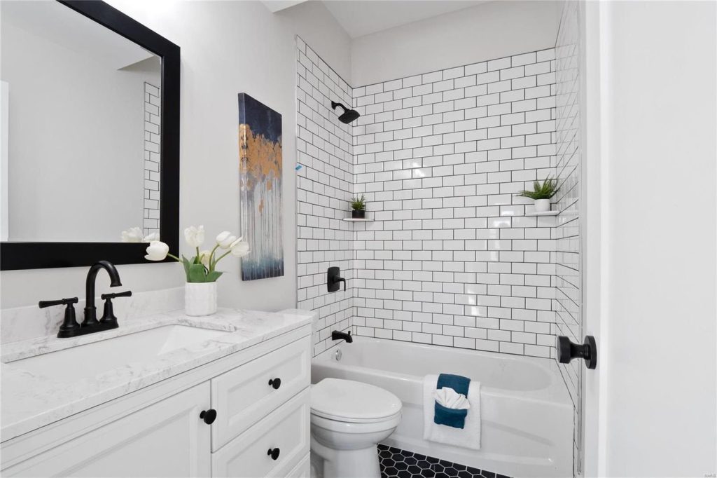 Bathroom with white vanity and subway tile tub surround