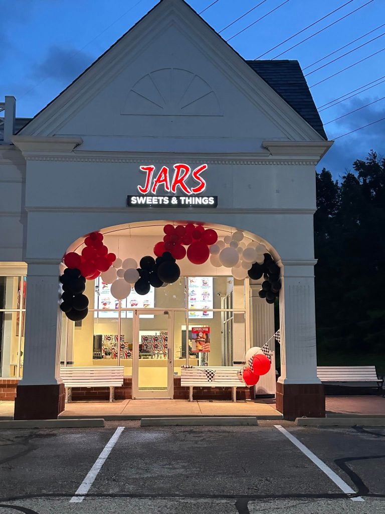 Shopfront at dusk with grand opening balloons