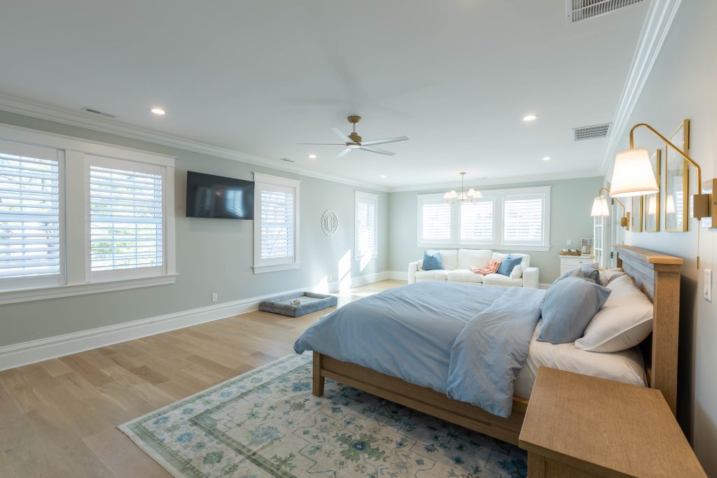 Primary bedroom with sitting area and wall-mounted TV
