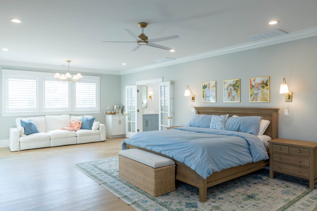Primary suite with sofa and French doors to the bathroom