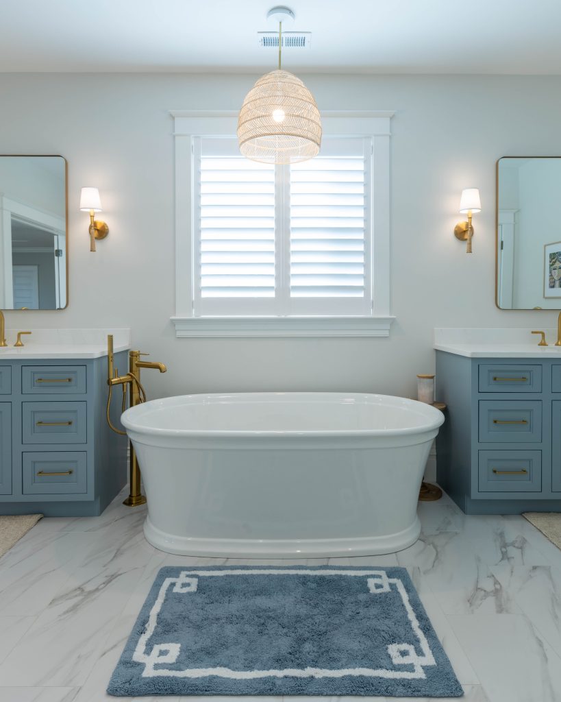 Freestanding tub centered between matching blue vanities