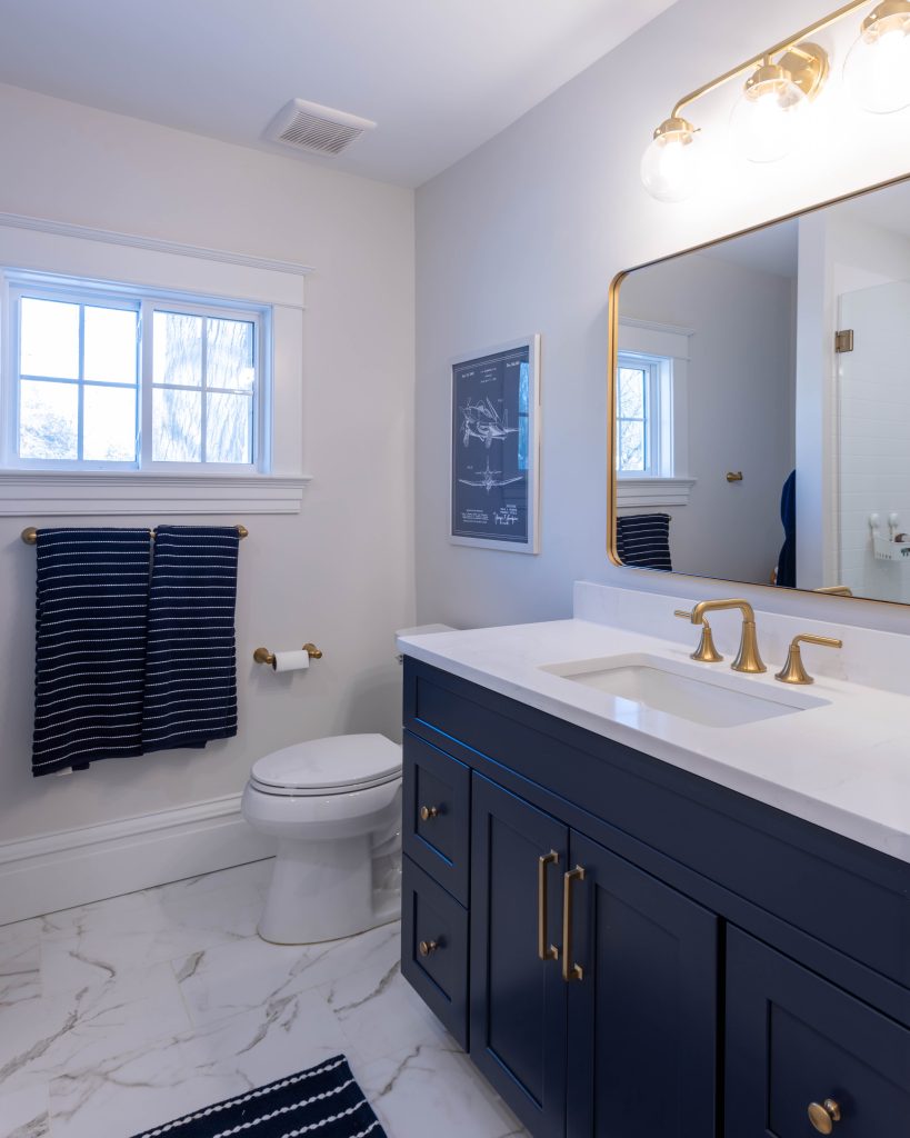 Bathroom with navy vanity and brass fixtures