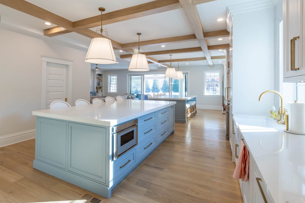 Kitchen island with beamed ceiling and blue cabinetry