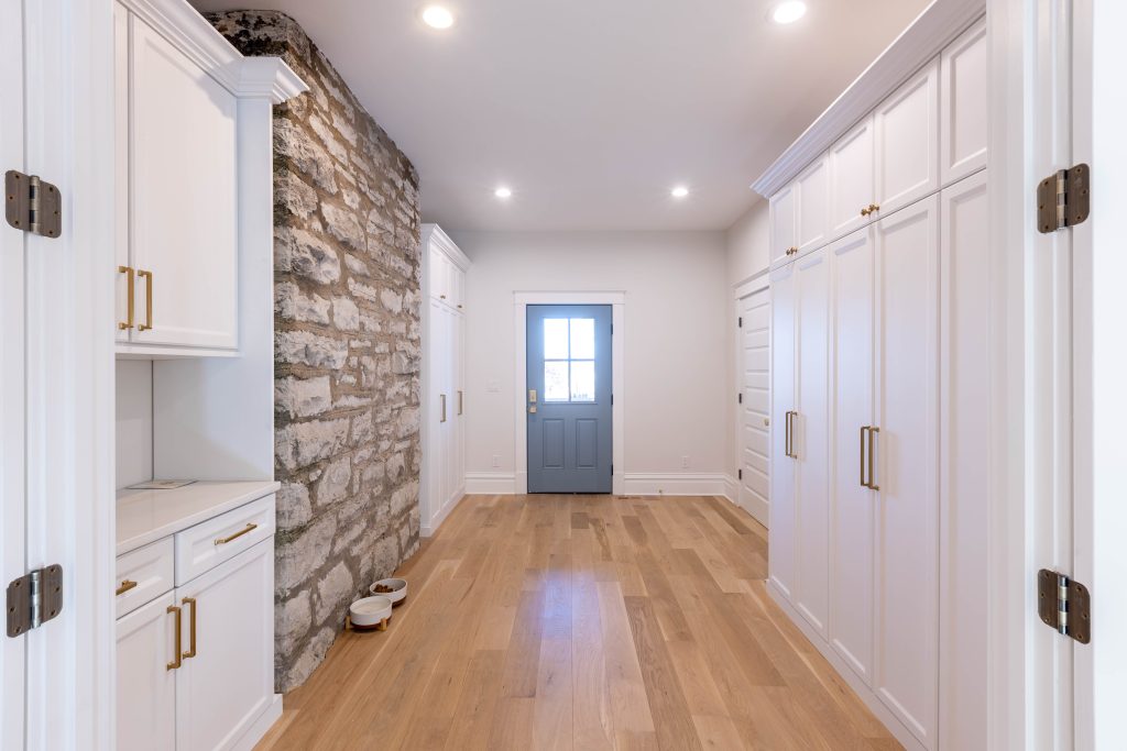 Mudroom hall with exposed stone wall and built-in lockers