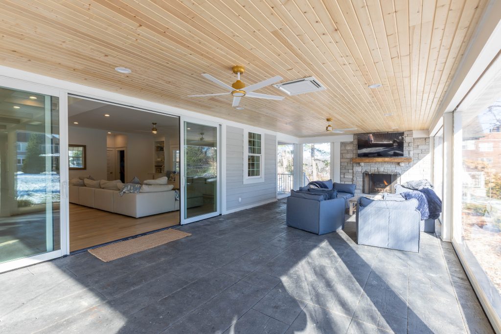 Covered porch with stone fireplace and pine ceiling
