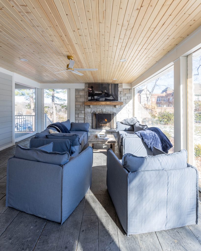 Porch seating grouped around the stone fireplace
