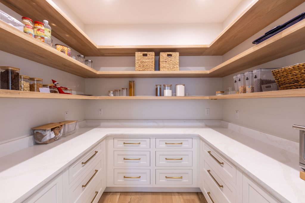 Walk-in pantry with oak shelving and quartz counters