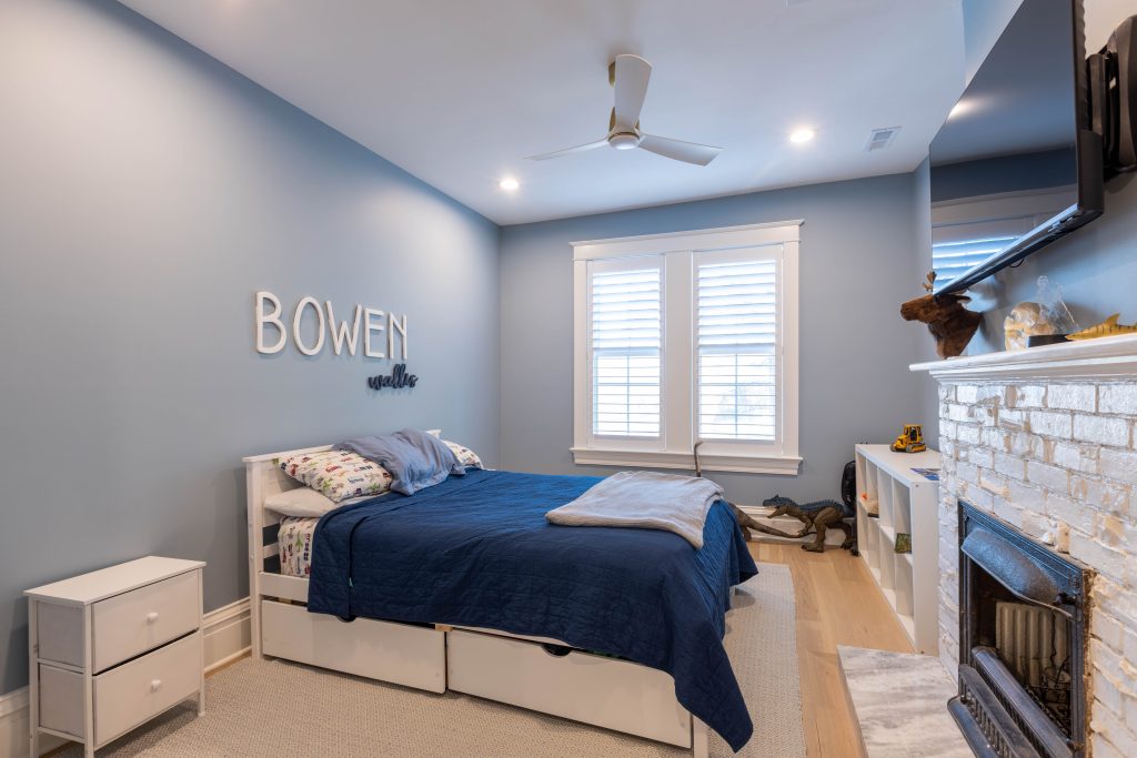 Child's bedroom with painted brick fireplace and storage bed