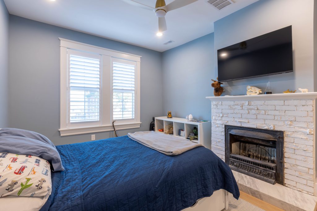 Bedroom fireplace with mounted TV and cubby shelving