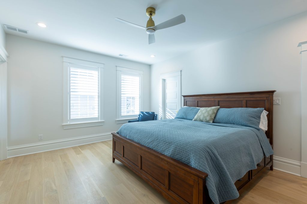 Guest bedroom with wood bed frame and light oak floors
