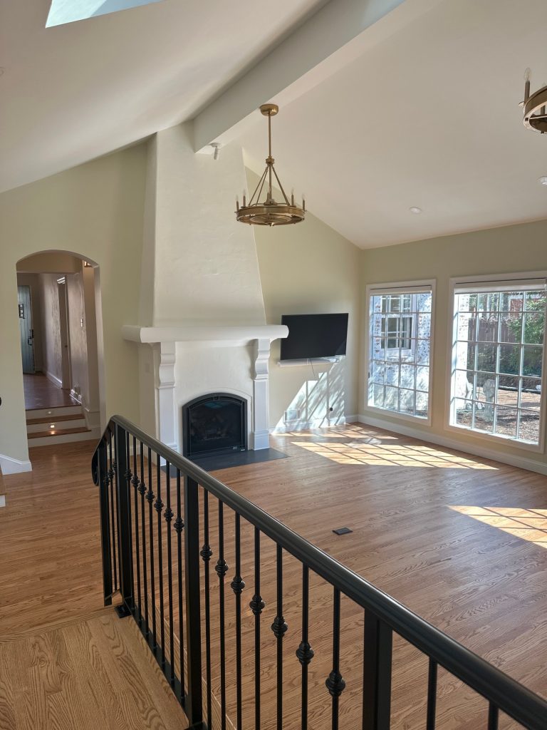 Great room with plaster fireplace and iron stair rail