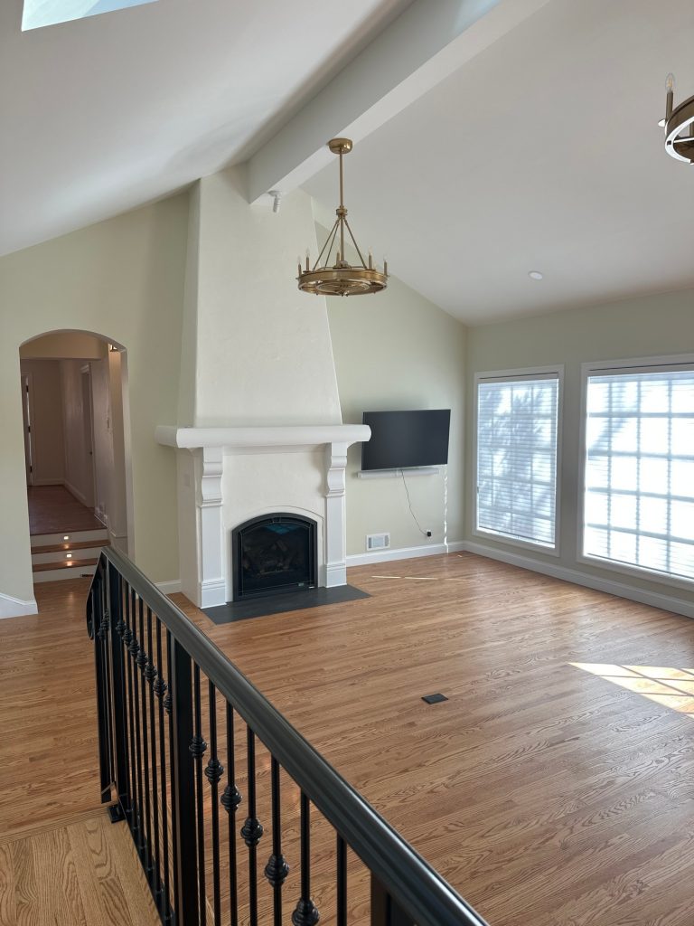 Vaulted great room with brass chandelier and fireplace