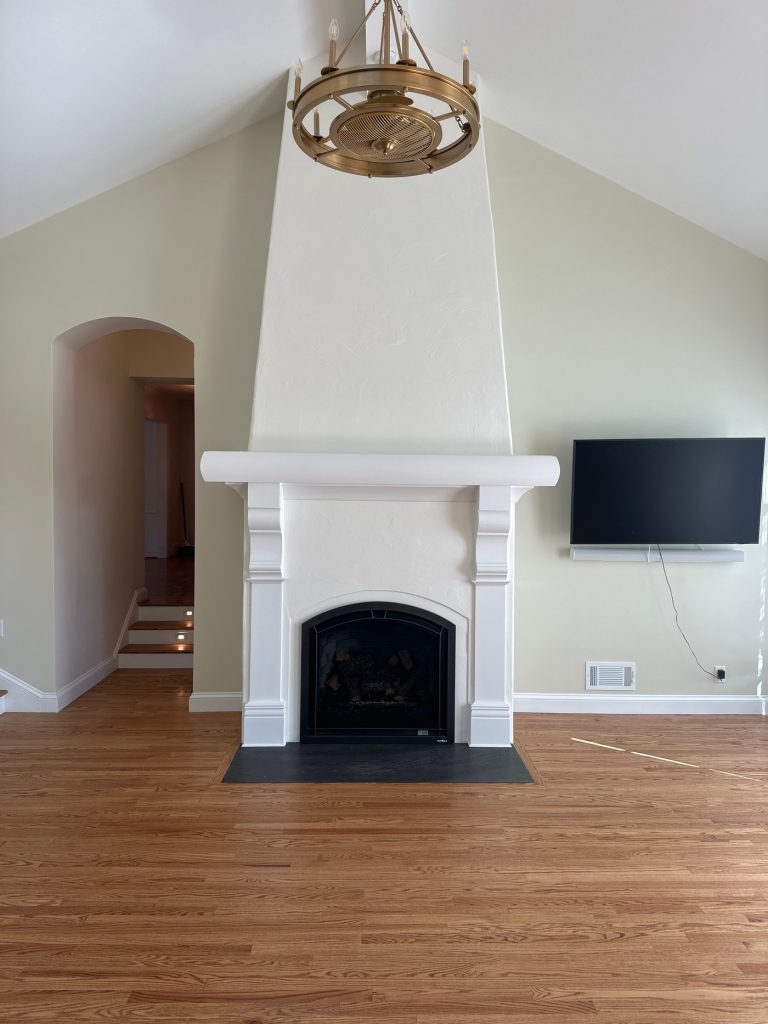 Tapered plaster chimney breast rising to the vaulted ceiling