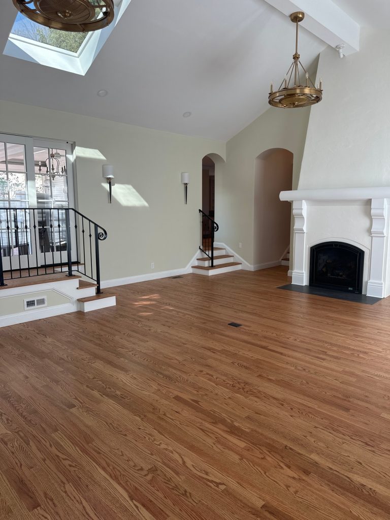 Great room with wall sconces and raised landing