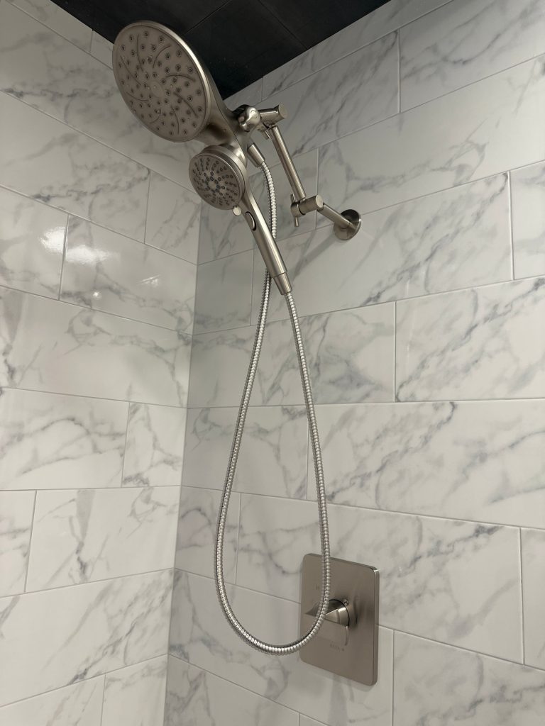 Rain and handheld shower fittings on marble tile