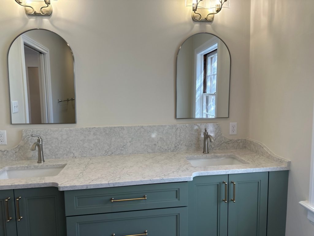 Quartz vanity top and backsplash with arched mirrors