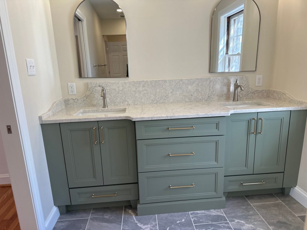 Sage vanity with brass pulls and gray tile floor