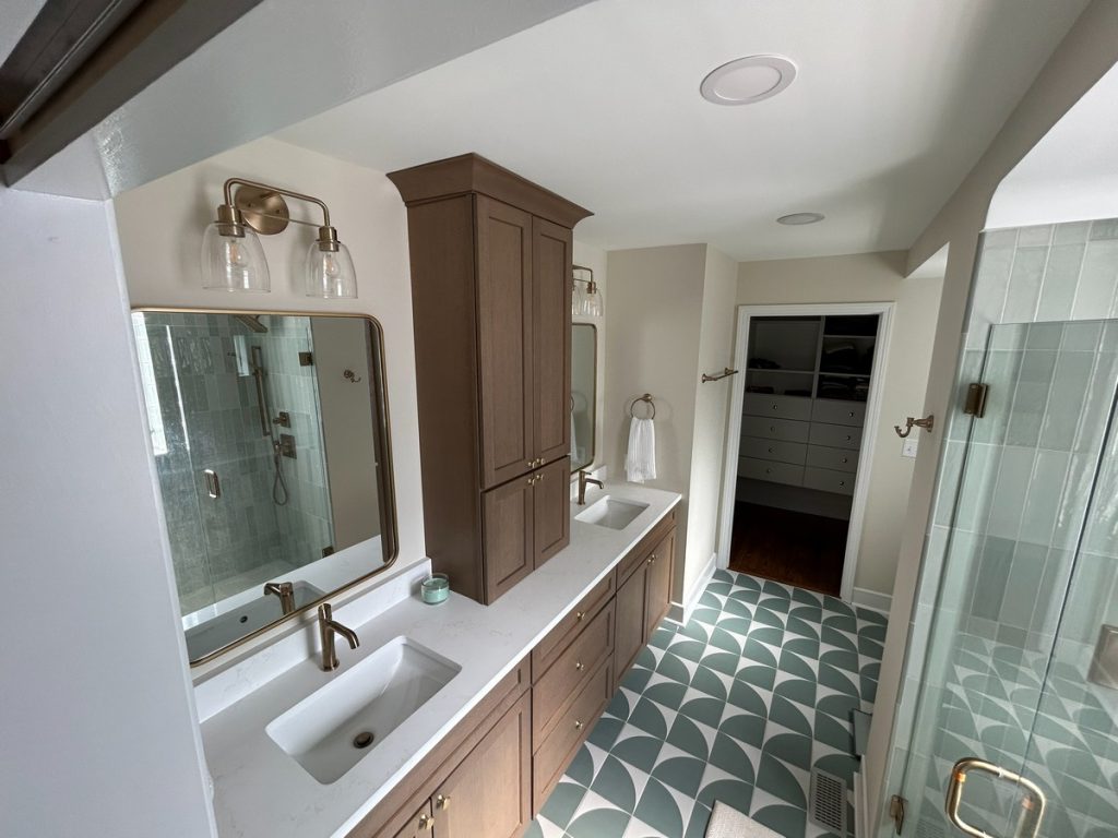 Bathroom with double vanity and patterned green floor tile