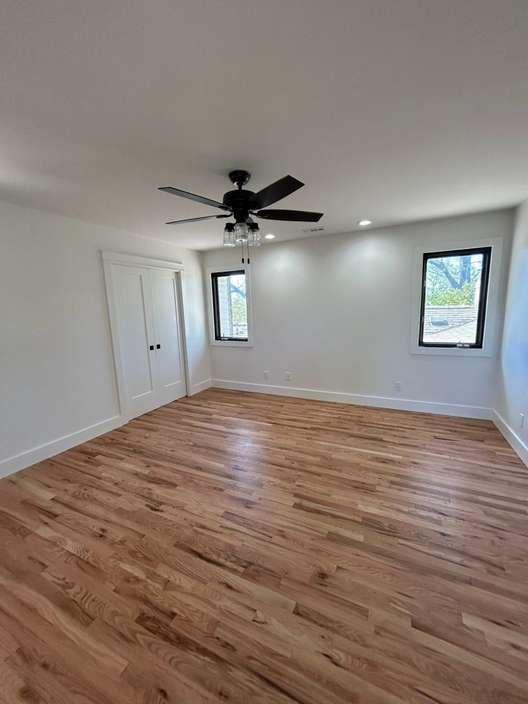 Bedroom with double closet doors and ceiling fan