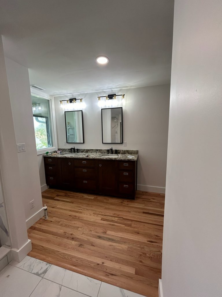 Double vanity with granite top and black framed mirrors