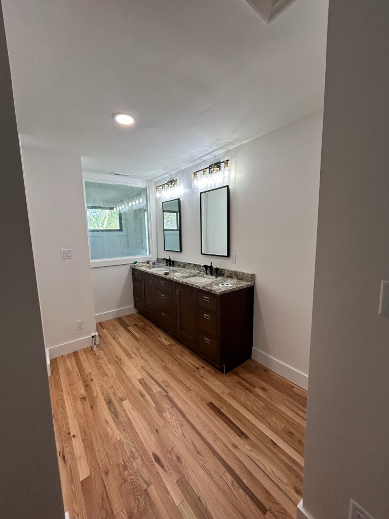 Dark wood vanity with twin mirrors and sconces