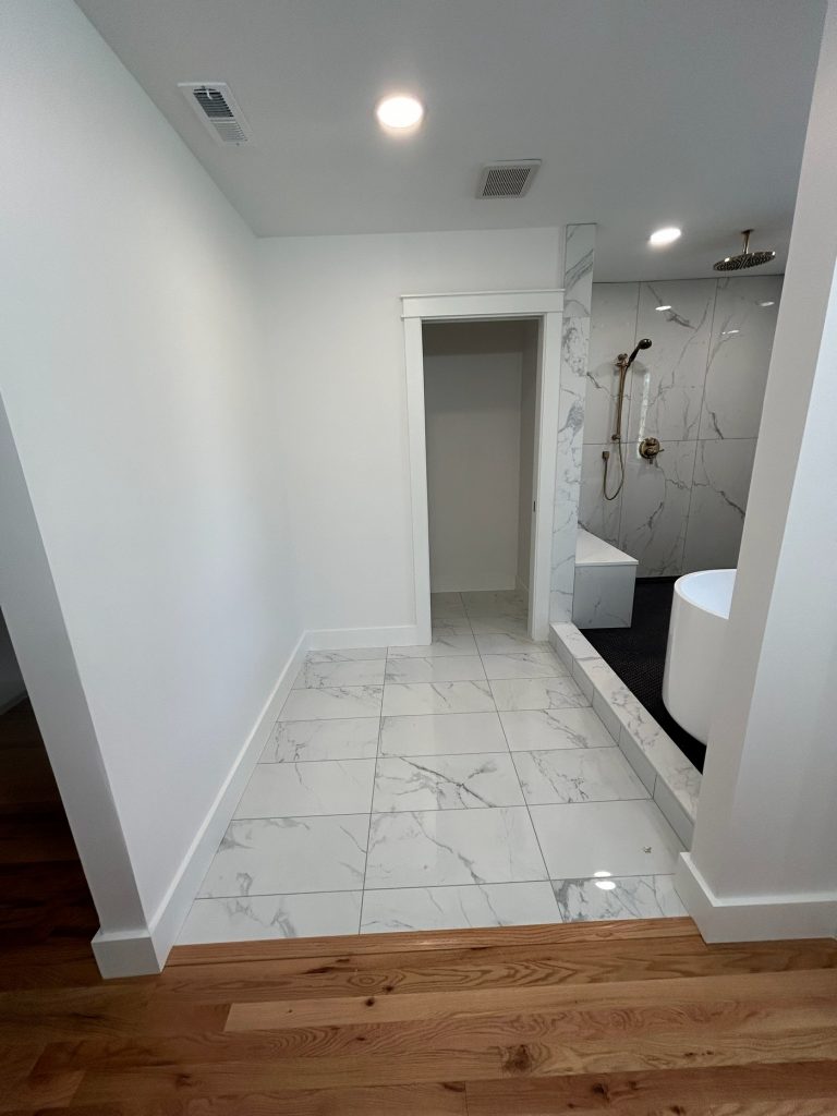 Bathroom entry with marble floor and wet room beyond