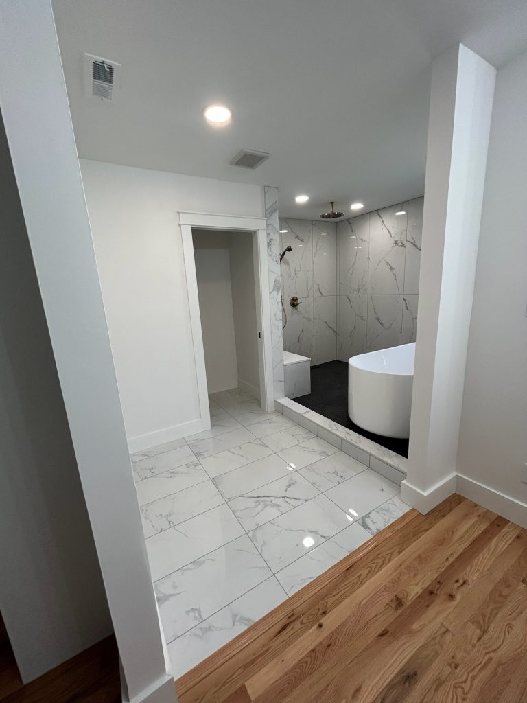 Marble-floored bathroom looking through to the wet room