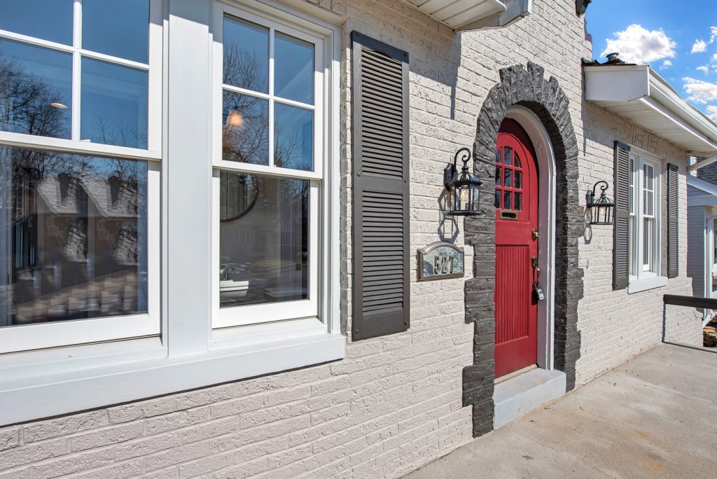 Red arched entry door with stone surround