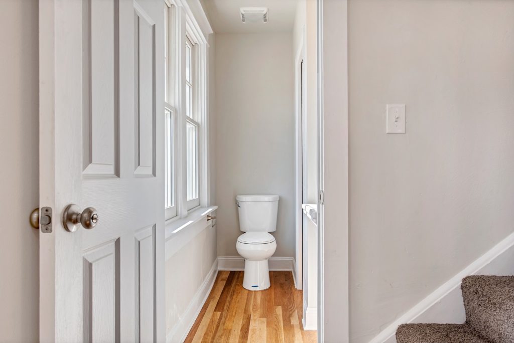 Compact toilet room beside the staircase