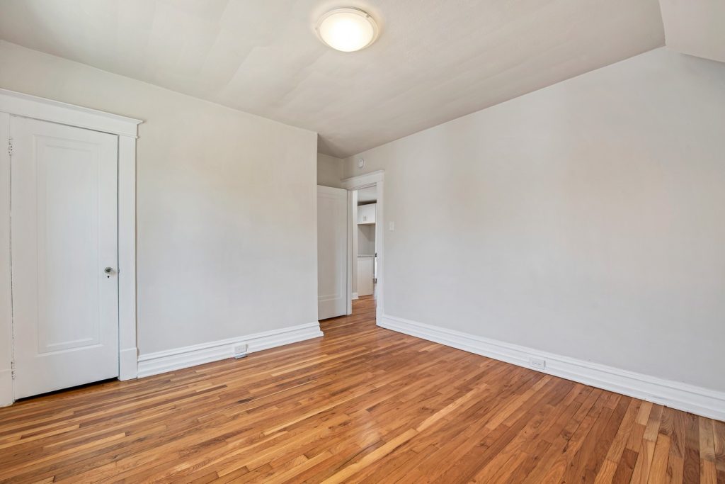 Empty bedroom with refinished hardwood floors