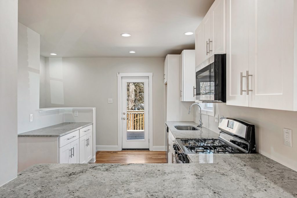 White kitchen with granite counters and gas range