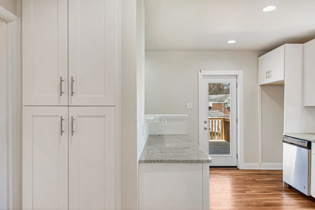 Floor to ceiling pantry cabinets beside the rear door