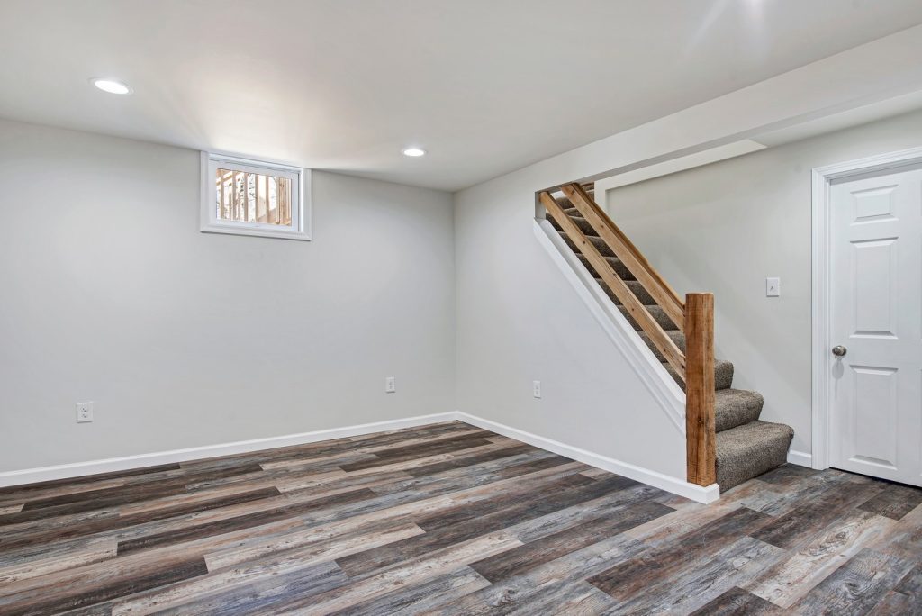 Finished lower level with plank flooring and stair