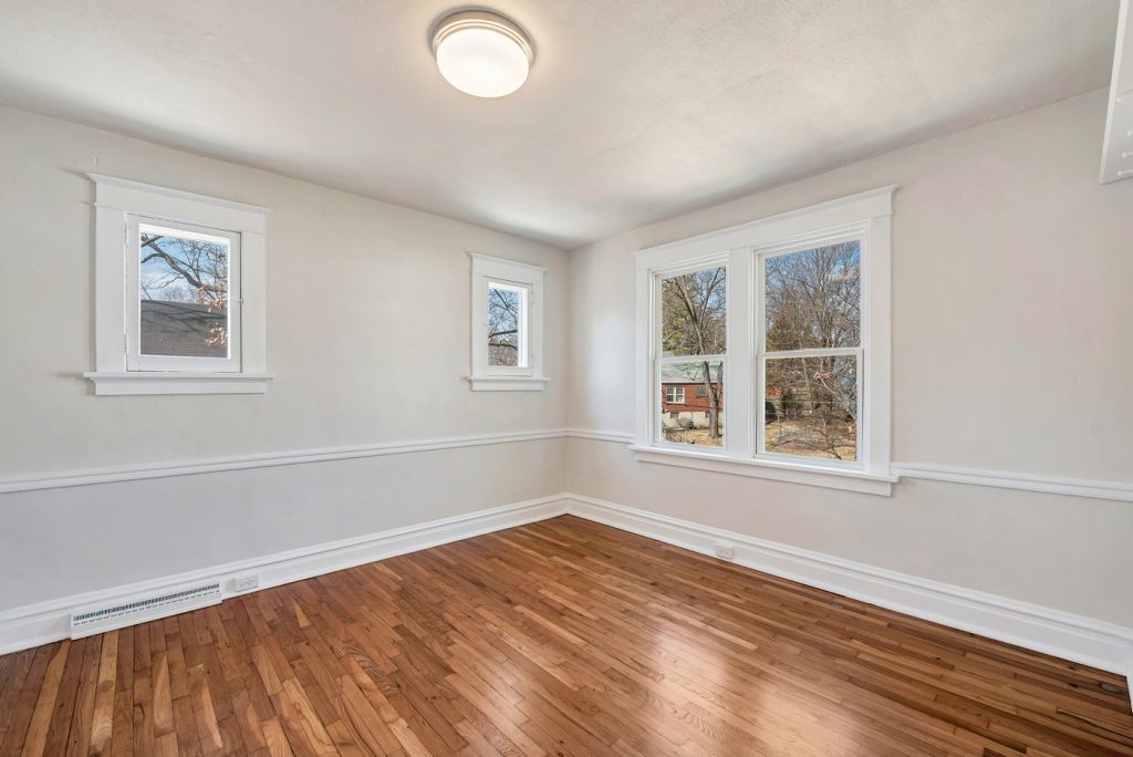 Bedroom with three windows and hardwood floors
