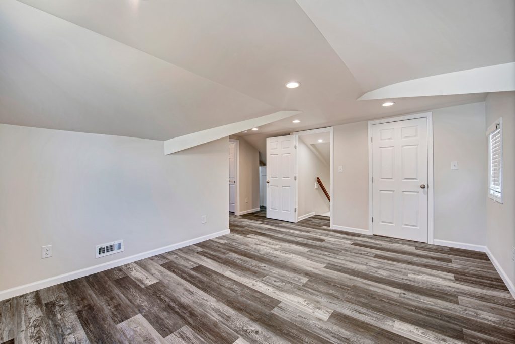 Upper level room with sloped ceilings and plank floor