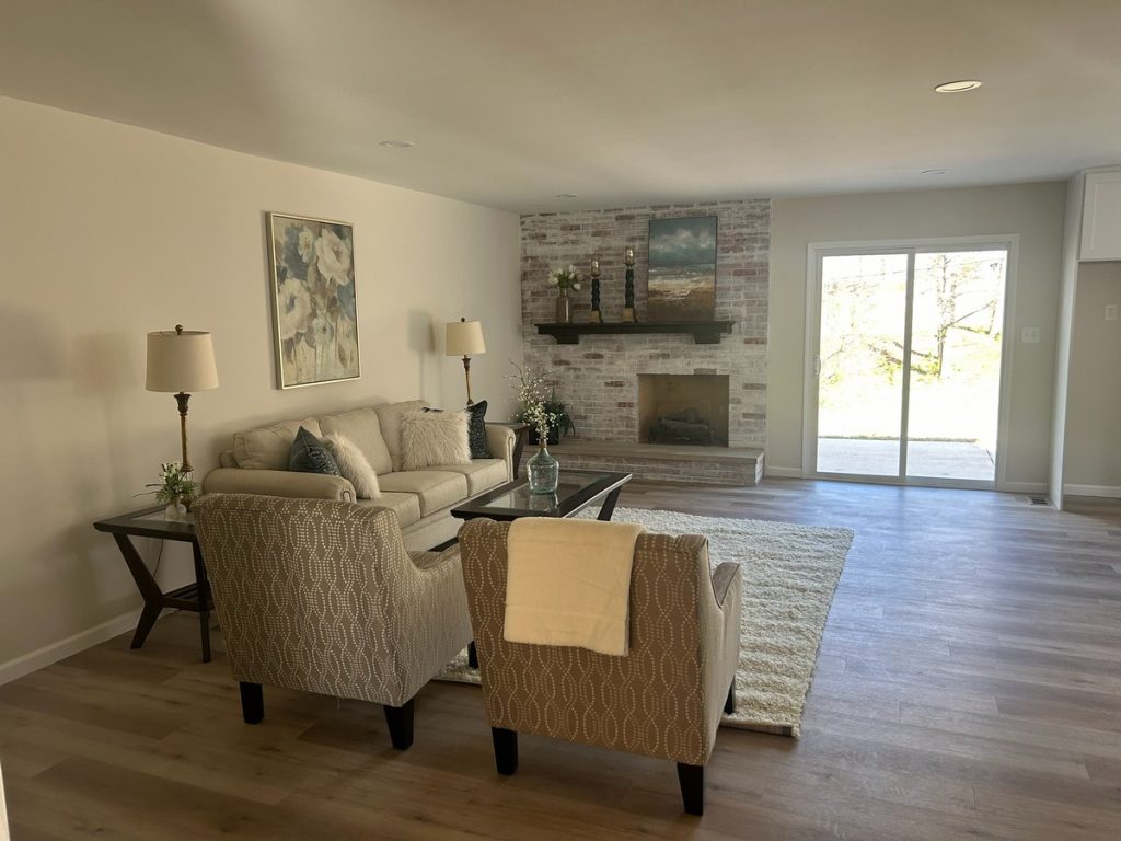 Family room with whitewashed brick fireplace and patio doors