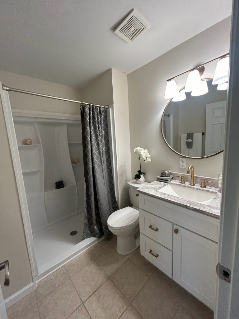 Bathroom with walk-in shower and round vanity mirror