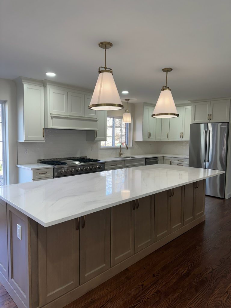 Kitchen island facing the gas range and custom hood