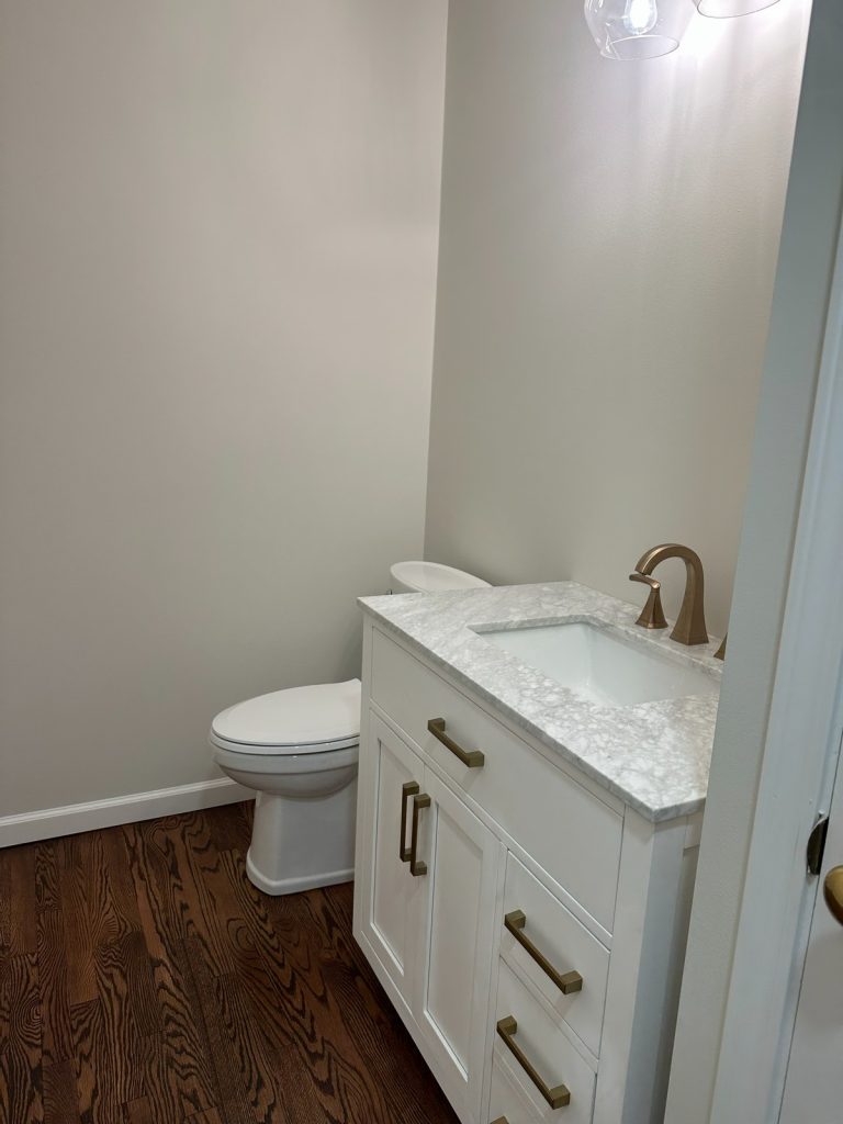 Powder room with white vanity and marble countertop