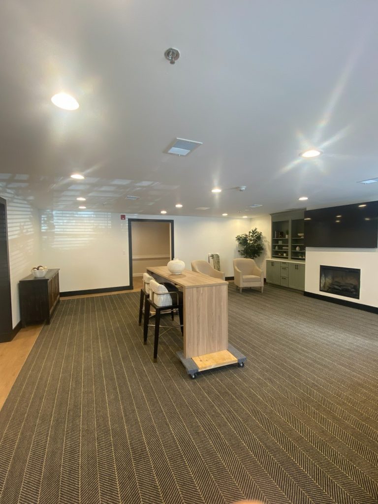 Common room with high-top table and gas fireplace