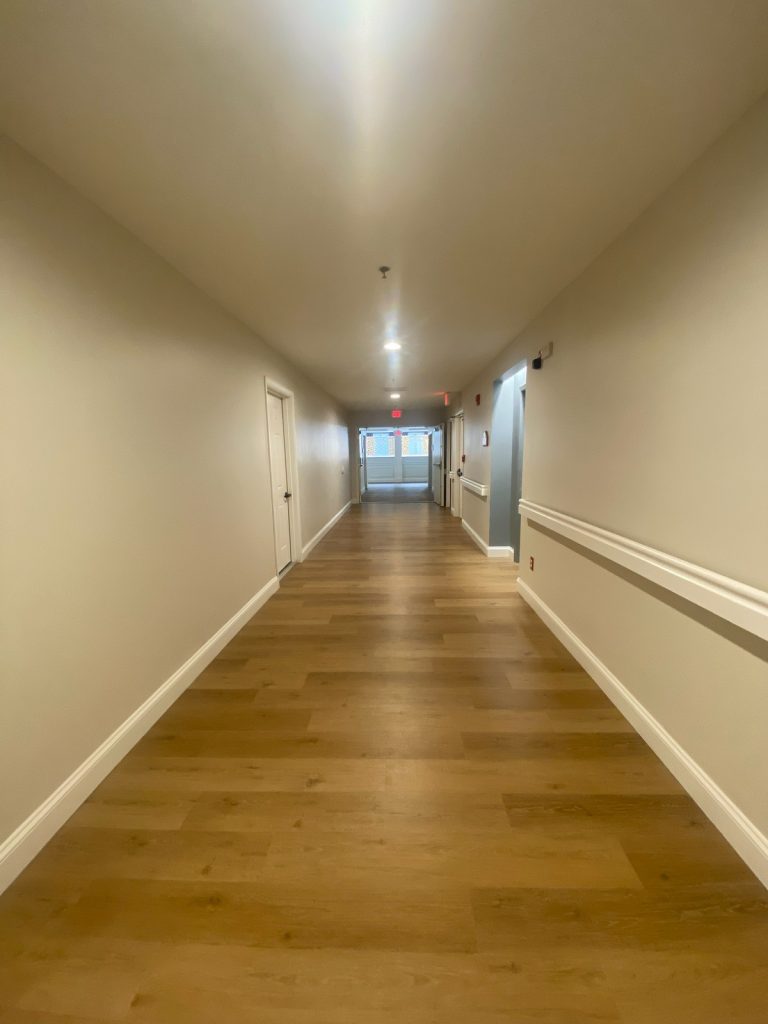 Long resident corridor with handrails and oak flooring