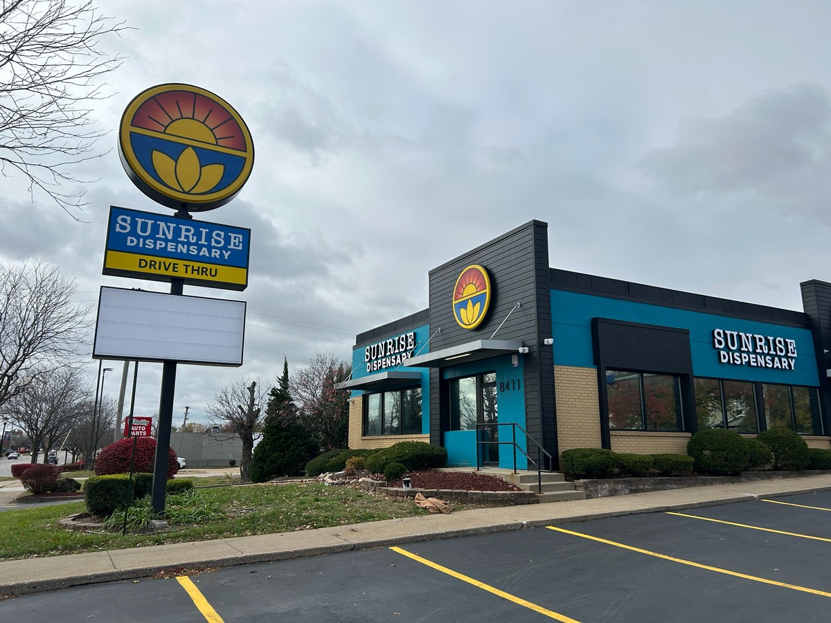 Dispensary exterior with illuminated pylon sign and drive-thru