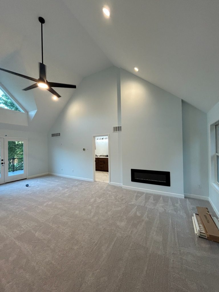 Vaulted bedroom with linear fireplace and ensuite doorway