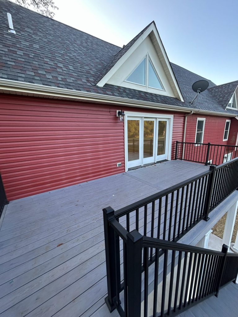Composite deck against red siding with patio doors