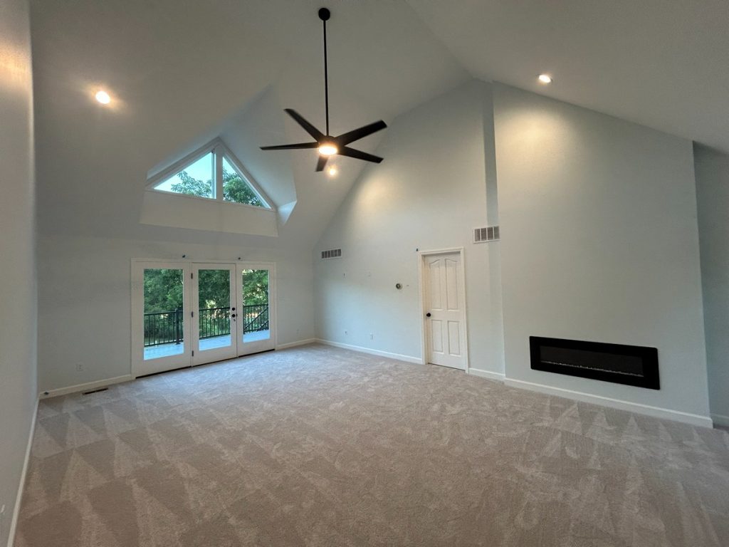 Vaulted room with French doors and triangular window