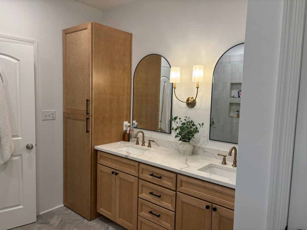 Bathroom vanity wall with linen tower and arched mirrors